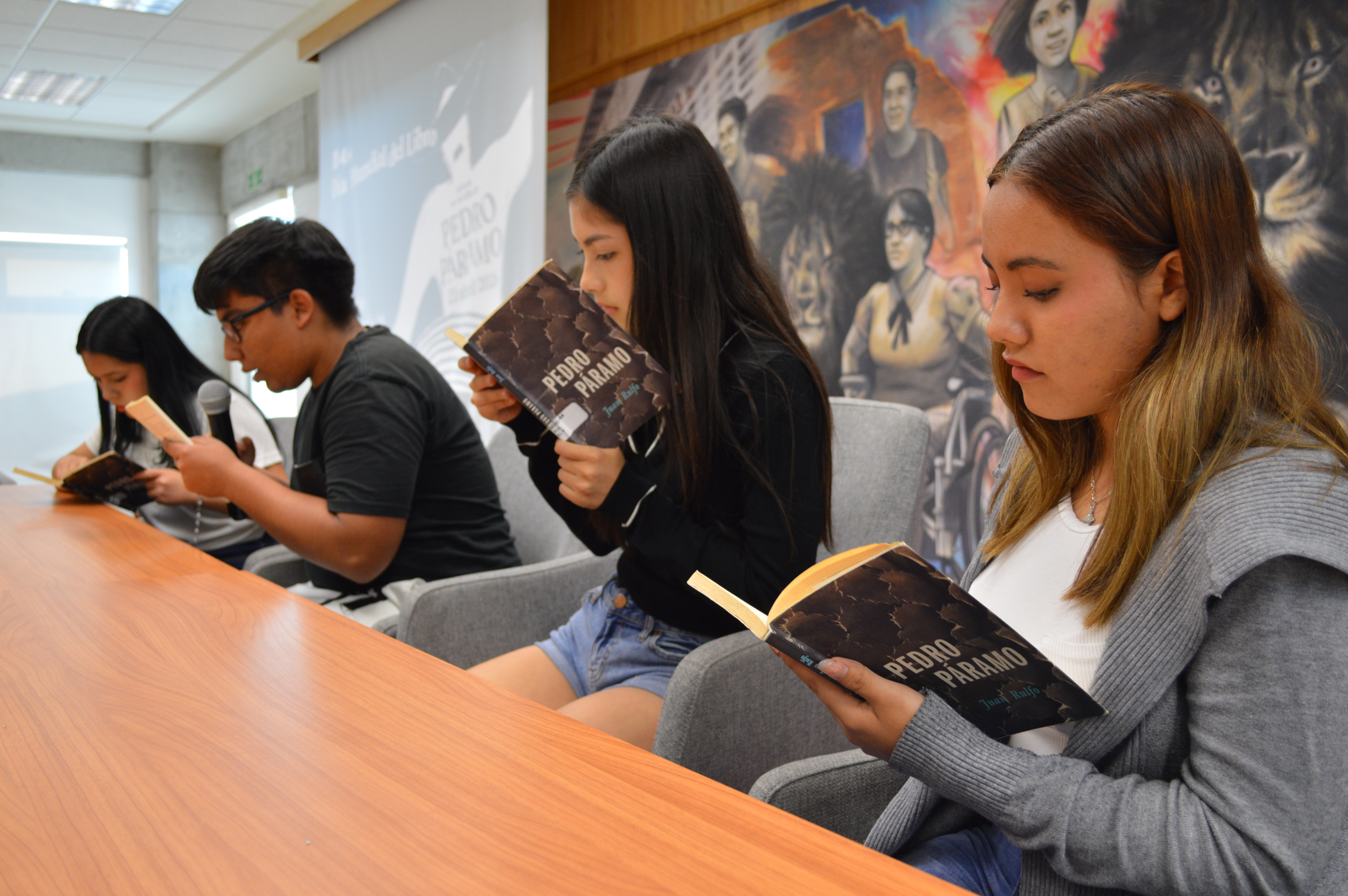 Jóvenes sentados leen libro