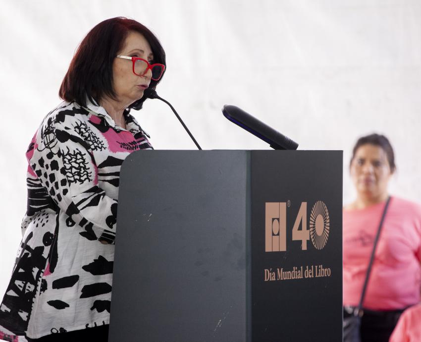 Mujer de pie lee libro en voz alta